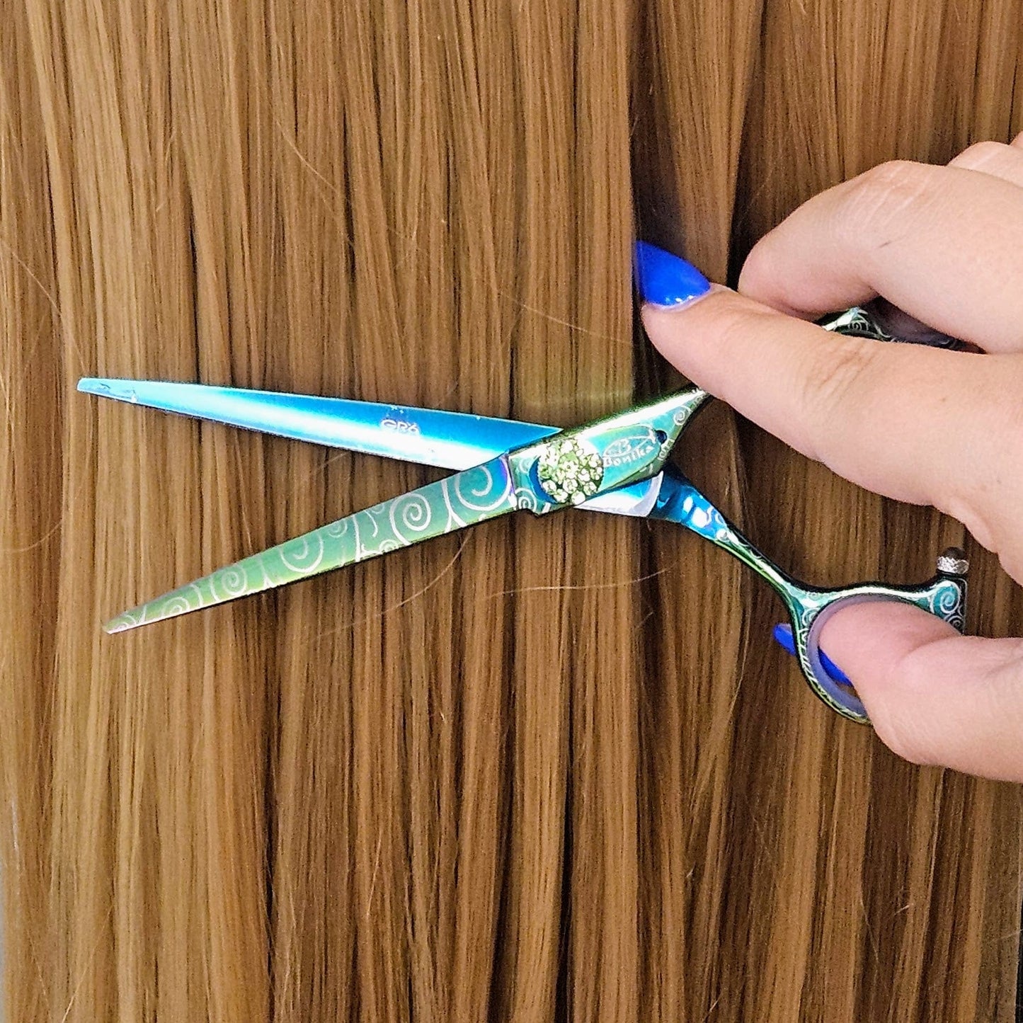 Bonika Poison Ivy multi-color hair shears in hand showing ergonomic design and 440C stainless steel